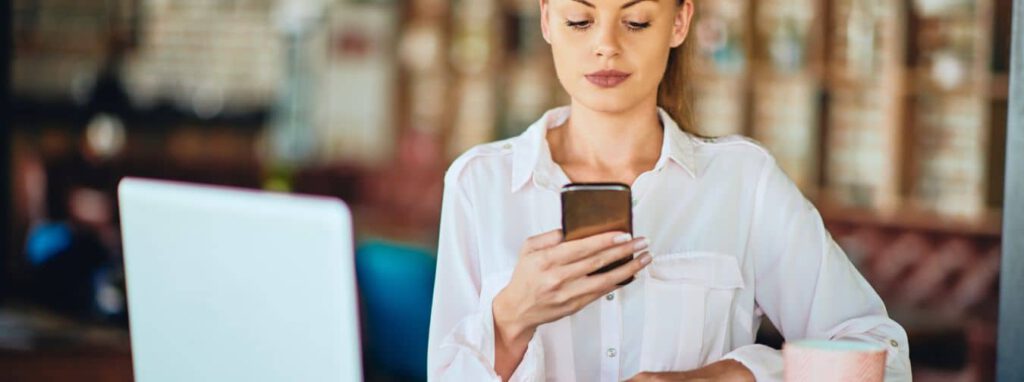 Website vs. Social Media Frau mit Handy und Laptop nutzt beides Business Website und Social Media Kanal