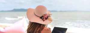 Frau am Strand mit Laptop und Sonnenhut Wieso Business Website Website Onlinekurs